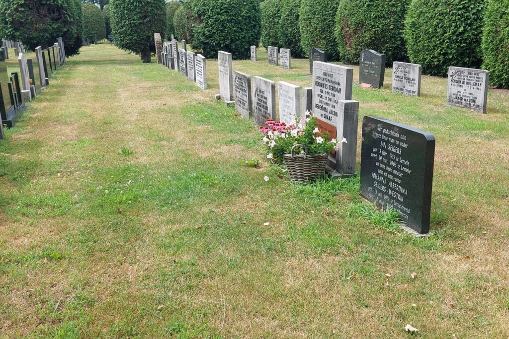 De oude begraafplaats na de renovatie, met een strak grasveld tussen de graven